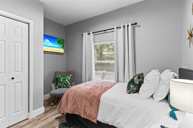 bedroom with light wood-type flooring and baseboards