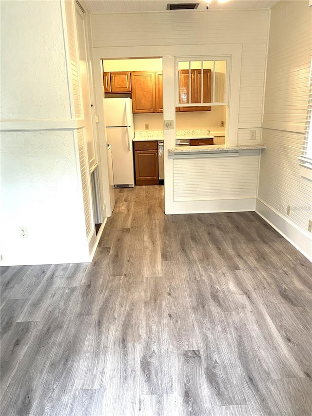 kitchen featuring stainless steel dishwasher, white fridge, and dark hardwood / wood-style flooring