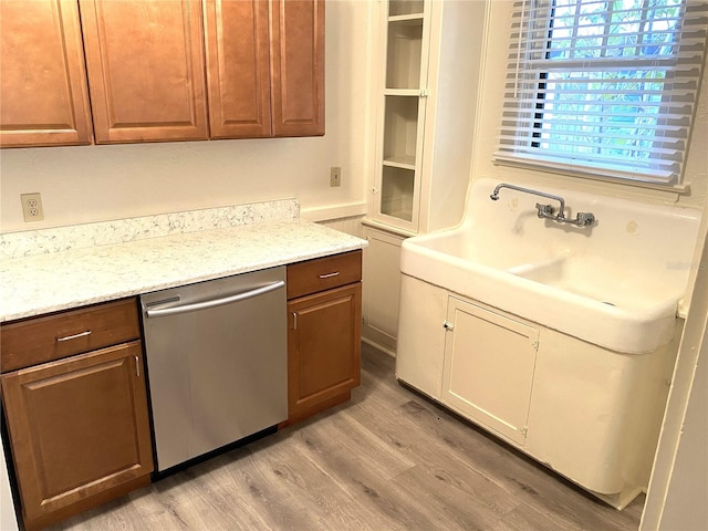 kitchen featuring dishwasher, light stone countertops, and light hardwood / wood-style flooring