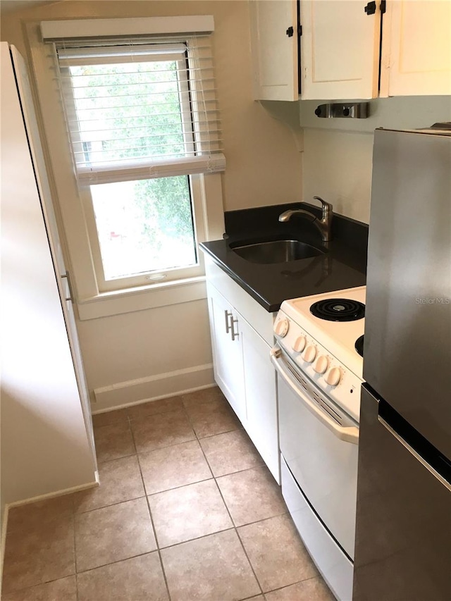 kitchen featuring sink, electric stove, stainless steel fridge, and light tile patterned floors