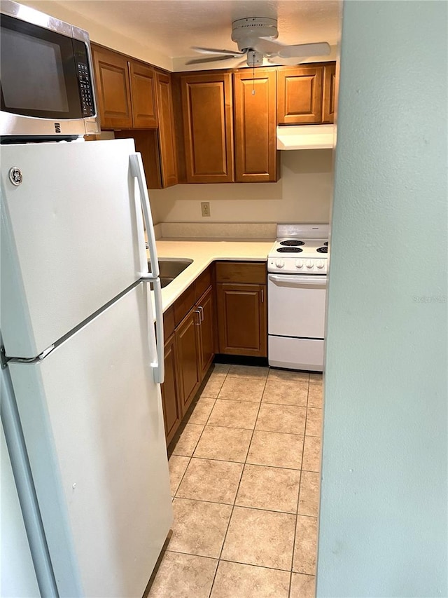 kitchen with light tile patterned flooring, ceiling fan, and white appliances