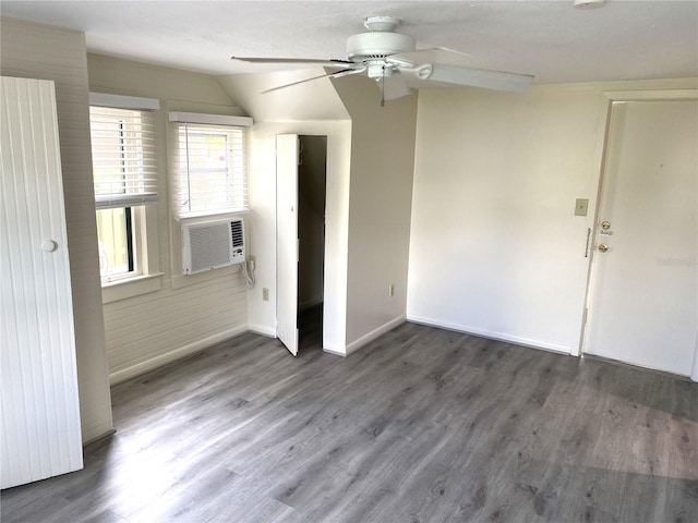 spare room featuring cooling unit, dark hardwood / wood-style floors, ceiling fan, and lofted ceiling