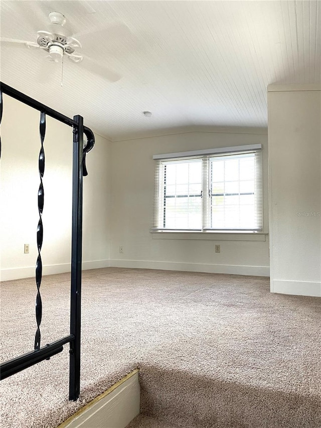 empty room with carpet flooring, vaulted ceiling, and ceiling fan