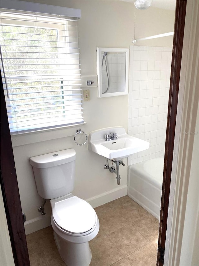 bathroom with tile patterned flooring, a healthy amount of sunlight, toilet, and sink