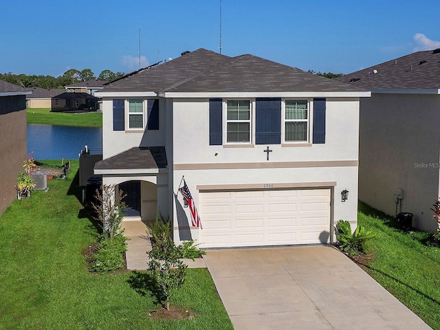 view of front of property featuring a front yard, central AC, and a garage