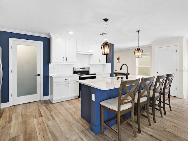 kitchen featuring pendant lighting, white cabinetry, an island with sink, a breakfast bar, and stainless steel electric range