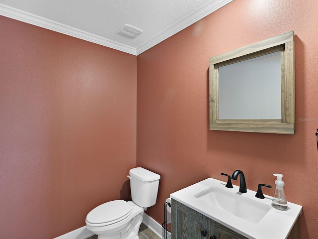 bathroom featuring toilet, vanity, crown molding, and a textured ceiling