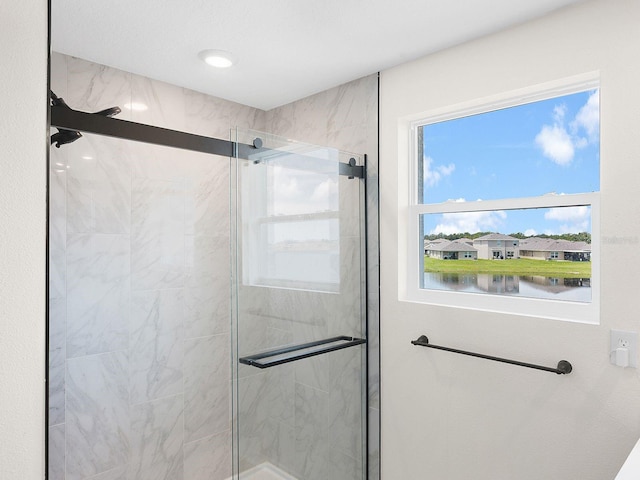 bathroom featuring a water view and a shower with shower door