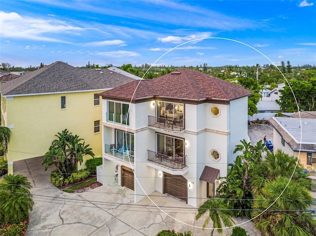 back of property featuring a balcony and a garage