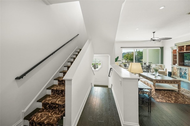 stairs featuring wood-type flooring and ceiling fan