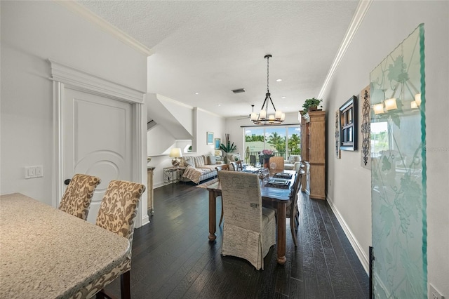 dining space with dark wood-type flooring, a textured ceiling, ornamental molding, and an inviting chandelier