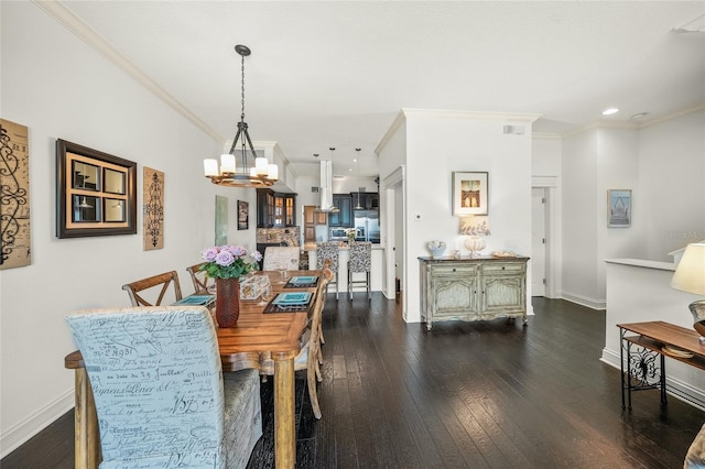 dining space with crown molding, dark hardwood / wood-style floors, and a chandelier