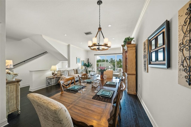 dining space with crown molding, dark hardwood / wood-style floors, and a chandelier