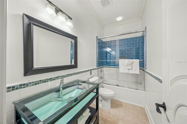 full bathroom with vanity, toilet, tiled shower / bath, and tile walls