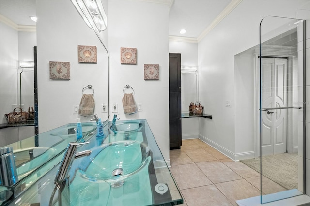 bathroom with tile patterned floors, a shower with door, double sink vanity, and crown molding