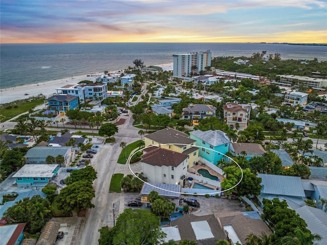 aerial view at dusk featuring a water view