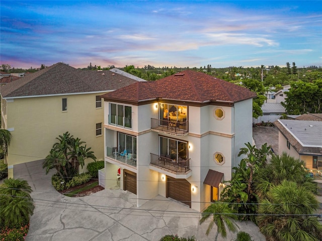 view of front of home with a garage and a balcony