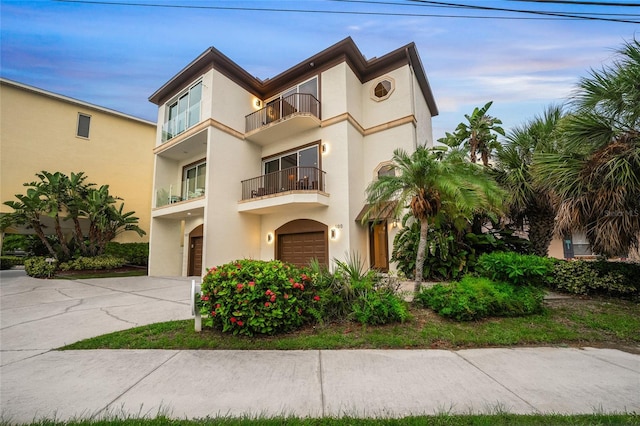 view of front of property with a garage and a balcony