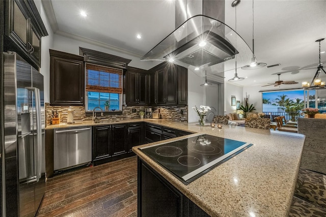 kitchen with stainless steel appliances, decorative backsplash, dark wood-type flooring, ceiling fan, and ornamental molding