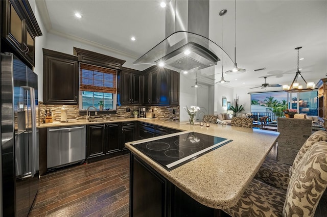 kitchen featuring tasteful backsplash, dark hardwood / wood-style floors, stainless steel appliances, island range hood, and ornamental molding