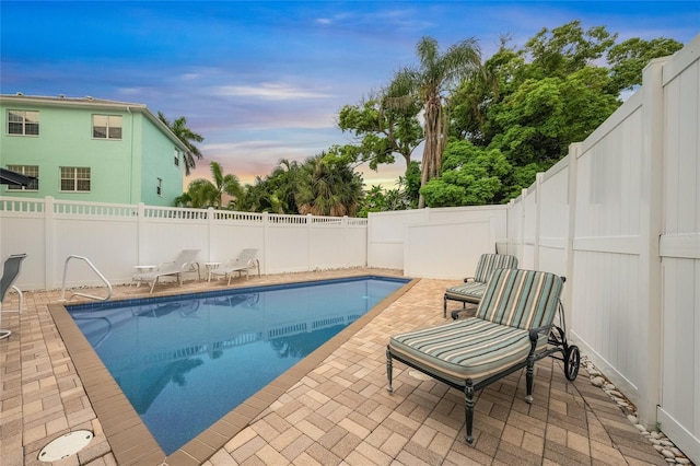 pool at dusk featuring a patio area