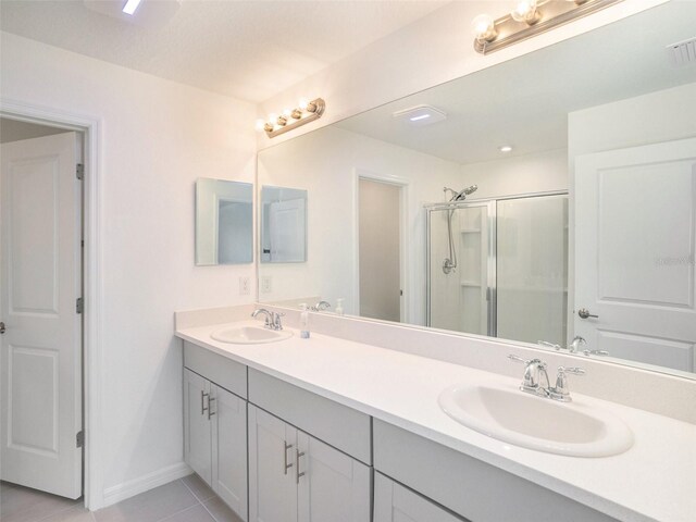 bathroom featuring tile patterned flooring, a shower with door, and vanity