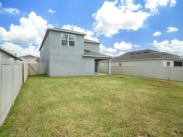 back of property featuring a lawn