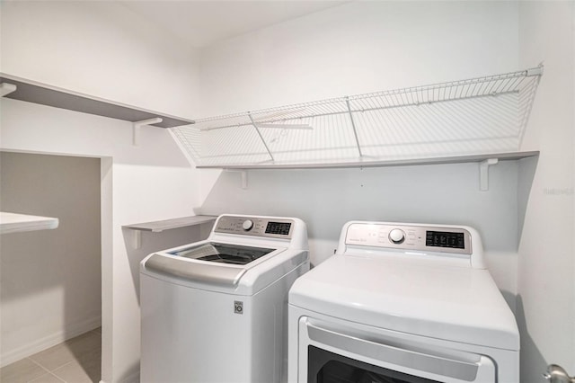 clothes washing area featuring light tile patterned flooring and separate washer and dryer