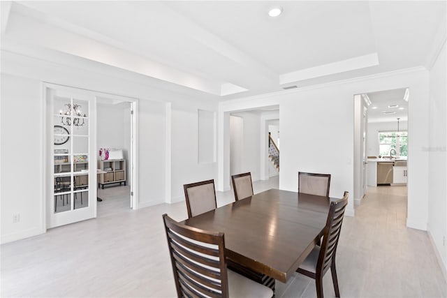 dining space featuring baseboards, stairway, a raised ceiling, and an inviting chandelier