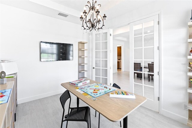 office area featuring light wood-type flooring and an inviting chandelier