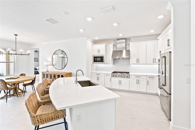 kitchen featuring a center island with sink, ventilation hood, stainless steel appliances, light countertops, and a sink