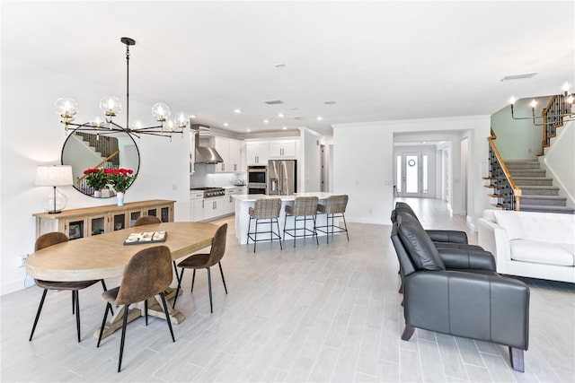 dining space featuring a notable chandelier, recessed lighting, stairway, ornamental molding, and light wood-style floors