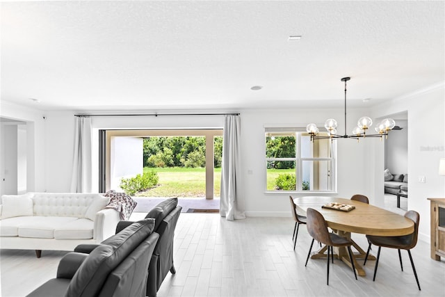 dining room featuring a healthy amount of sunlight, an inviting chandelier, baseboards, and a textured ceiling