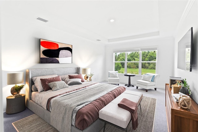 bedroom with carpet floors, a raised ceiling, visible vents, and baseboards