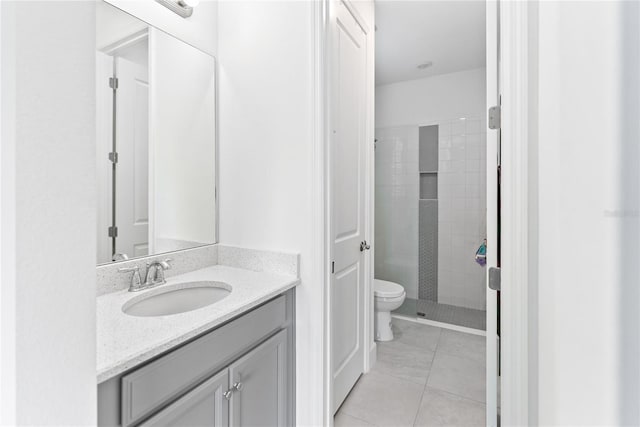 bathroom featuring toilet, a stall shower, vanity, and tile patterned floors