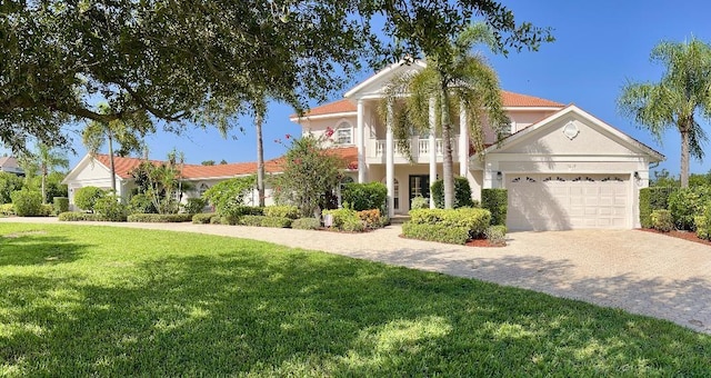 view of front of home with a balcony, a garage, and a front lawn