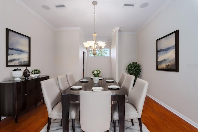 dining room with a notable chandelier, crown molding, and hardwood / wood-style floors