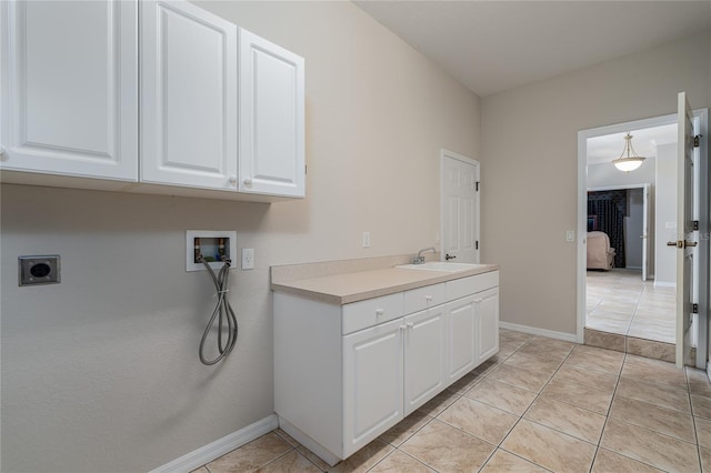 laundry area with light tile patterned floors, washer hookup, cabinets, electric dryer hookup, and sink