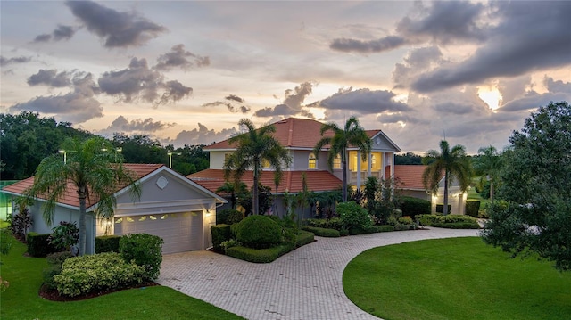 view of front of house featuring a garage and a lawn