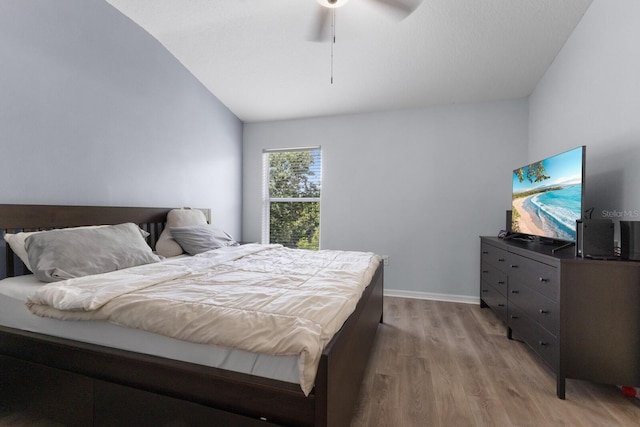 bedroom featuring ceiling fan, lofted ceiling, and light hardwood / wood-style floors