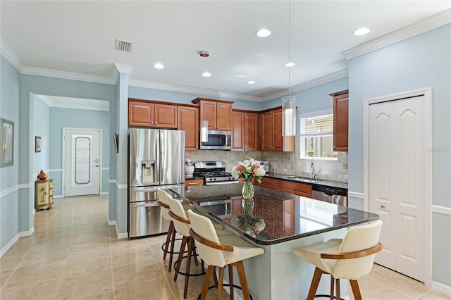 kitchen with sink, stainless steel appliances, a center island, a kitchen bar, and light tile patterned flooring