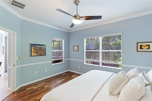 bedroom featuring dark wood-type flooring, ceiling fan, and ornamental molding