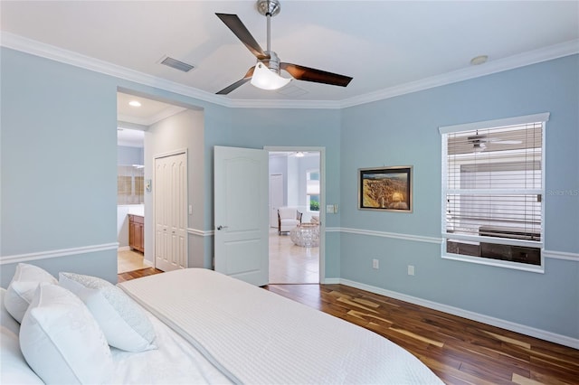 bedroom with crown molding, ceiling fan, hardwood / wood-style floors, ensuite bathroom, and a closet