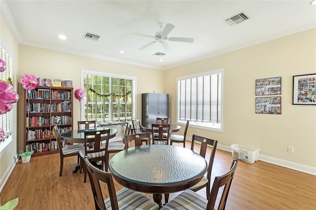 dining space with crown molding, ceiling fan, and light wood-type flooring