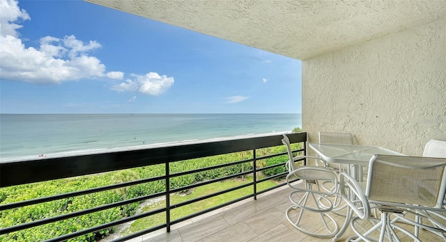 balcony featuring a beach view and a water view