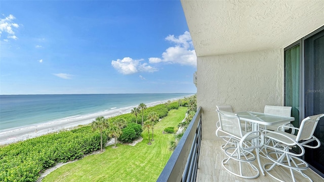 balcony featuring a view of the beach and a water view