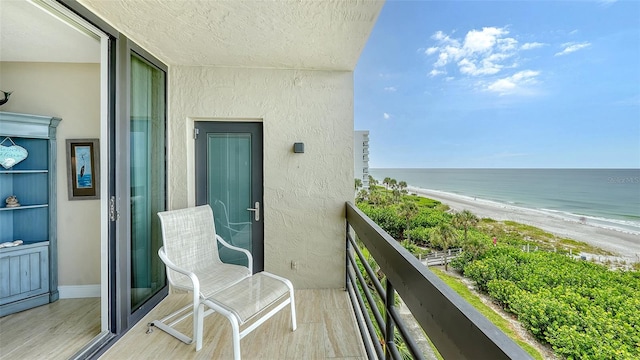 balcony featuring a water view and a beach view