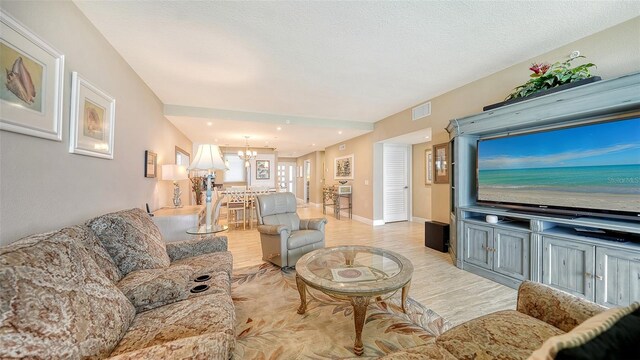 living room featuring a chandelier and light hardwood / wood-style floors