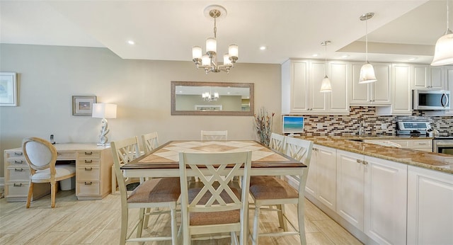 kitchen with an inviting chandelier, white cabinets, stainless steel appliances, light stone countertops, and decorative backsplash