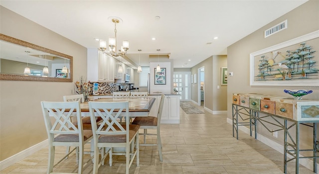 tiled dining room featuring an inviting chandelier